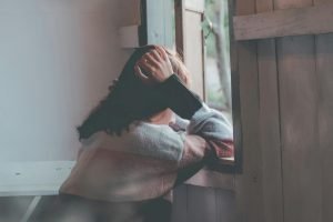 Photo of a Person Leaning on Wooden Window